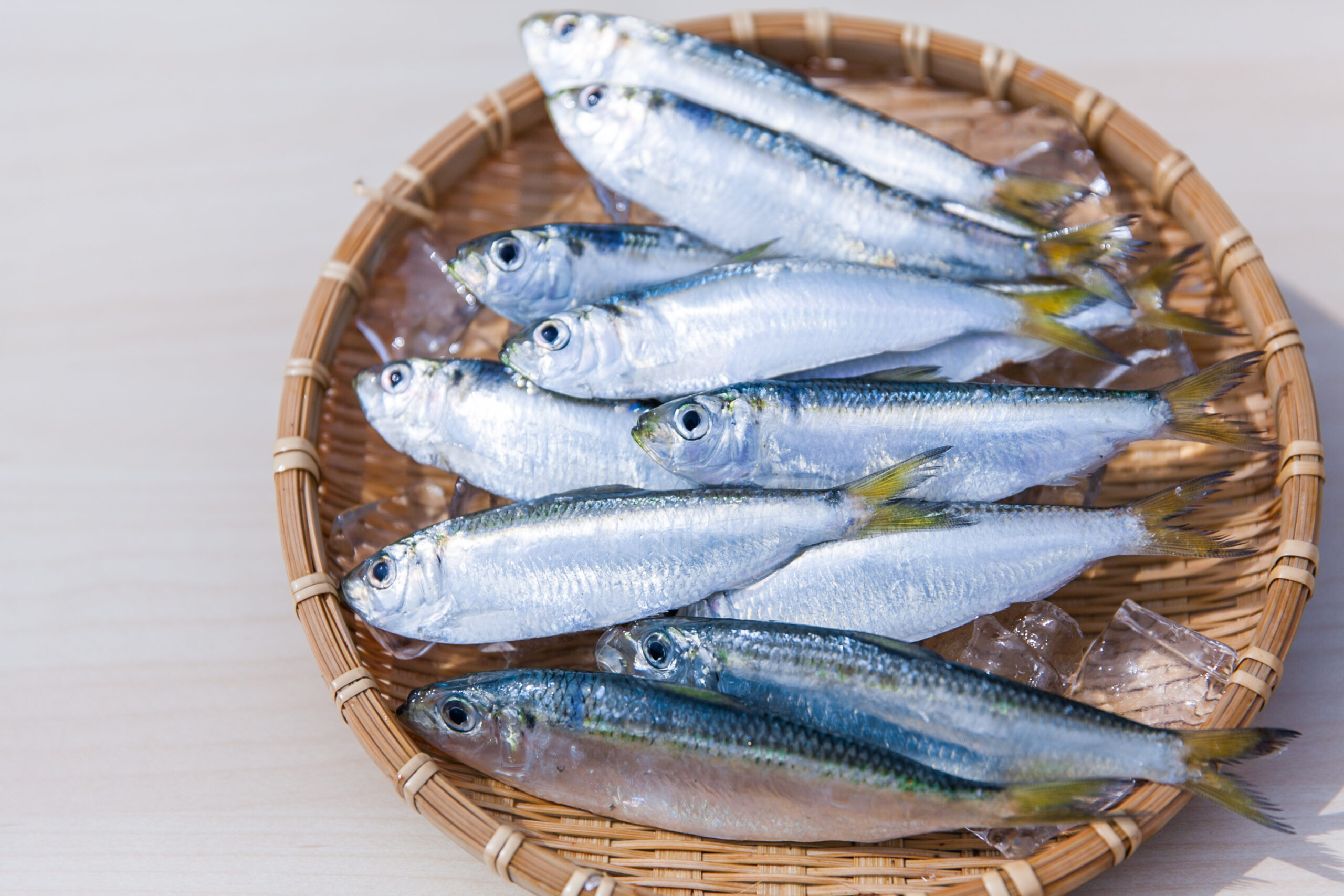 Basket of small, fresh fish on ice, ready for market or display in a wicker basket