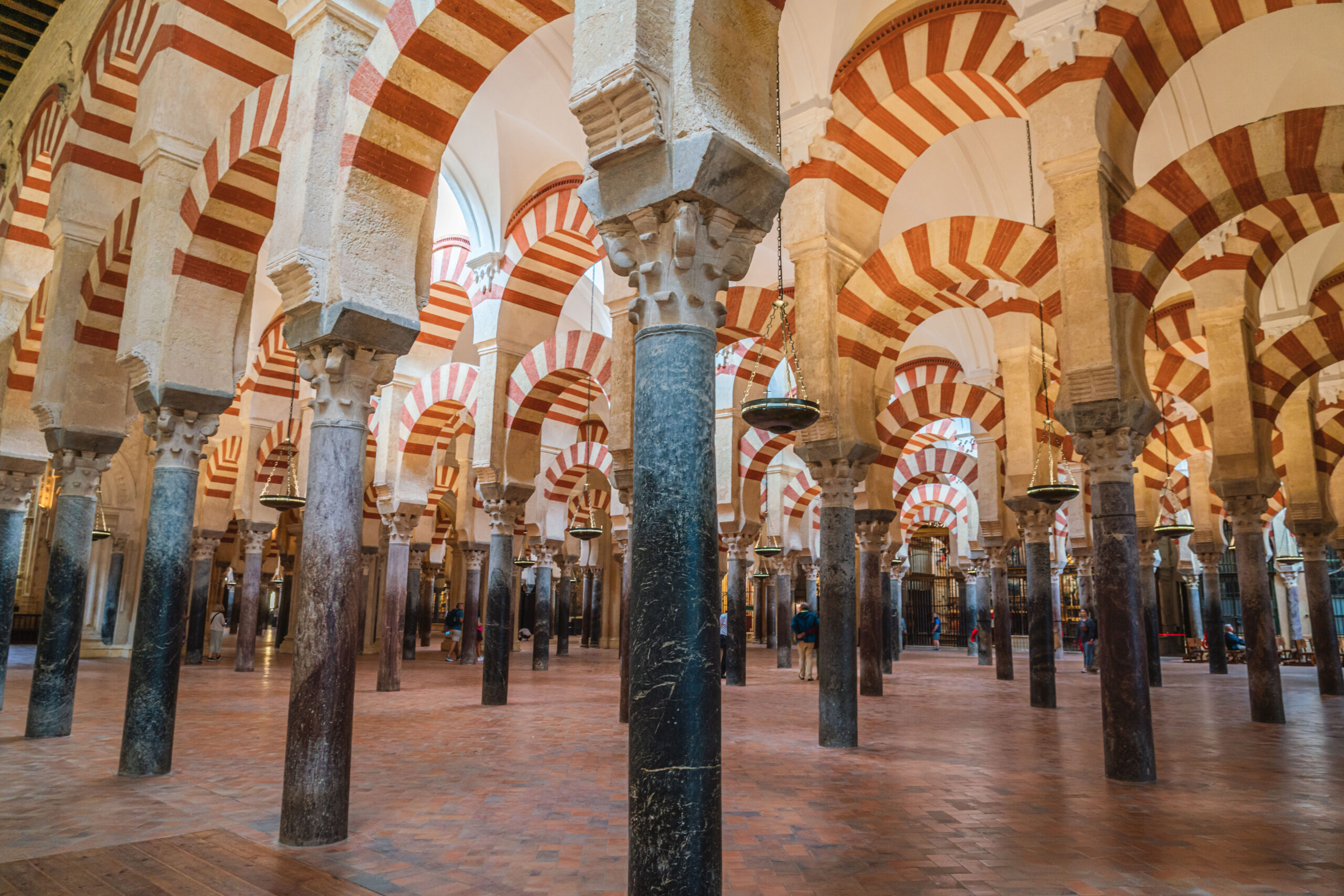 Interior of the Mezquita: rows of red-and-white striped arches supported by marble columns.
