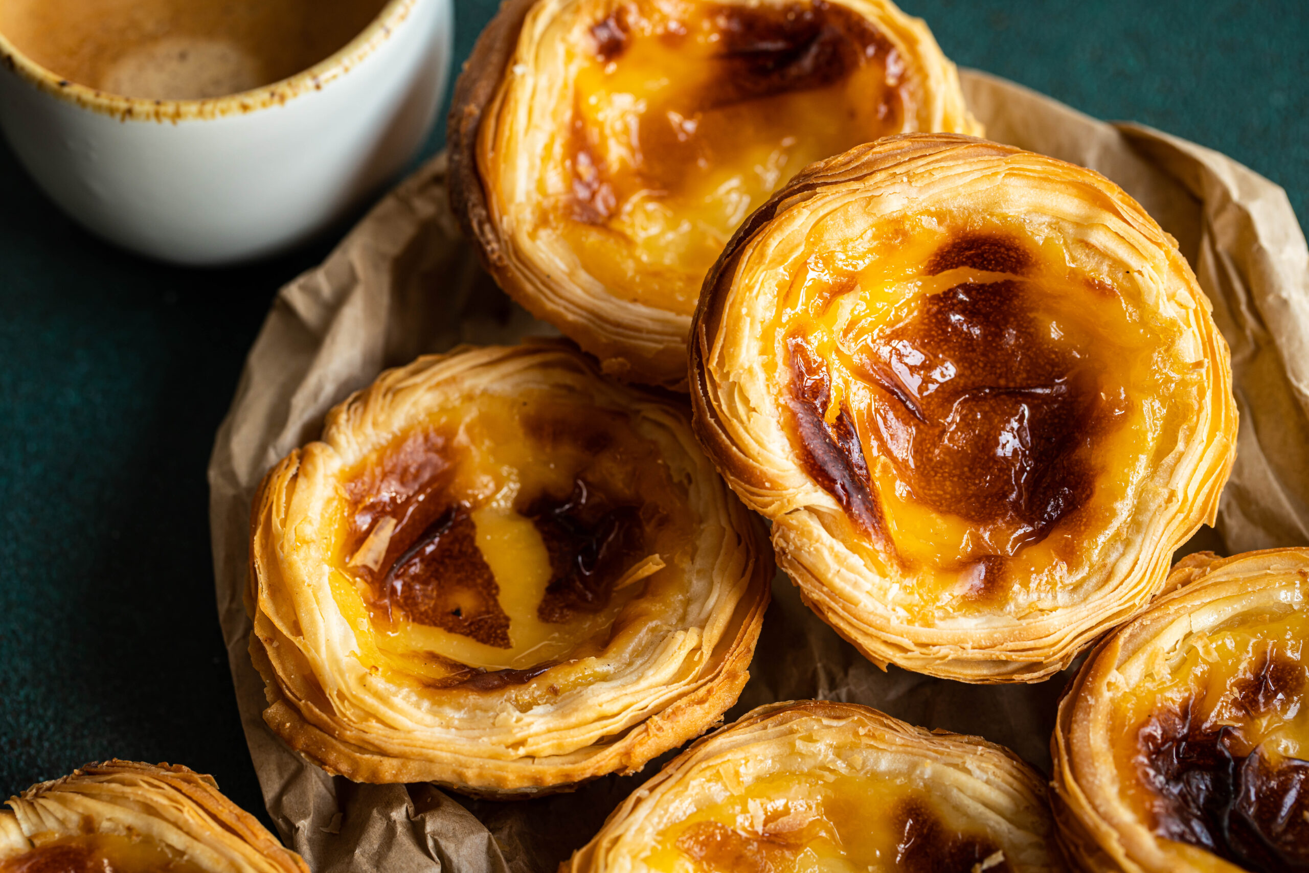 Golden-brown, flaky cheese pastries with glossy centers arranged on parchment paper.