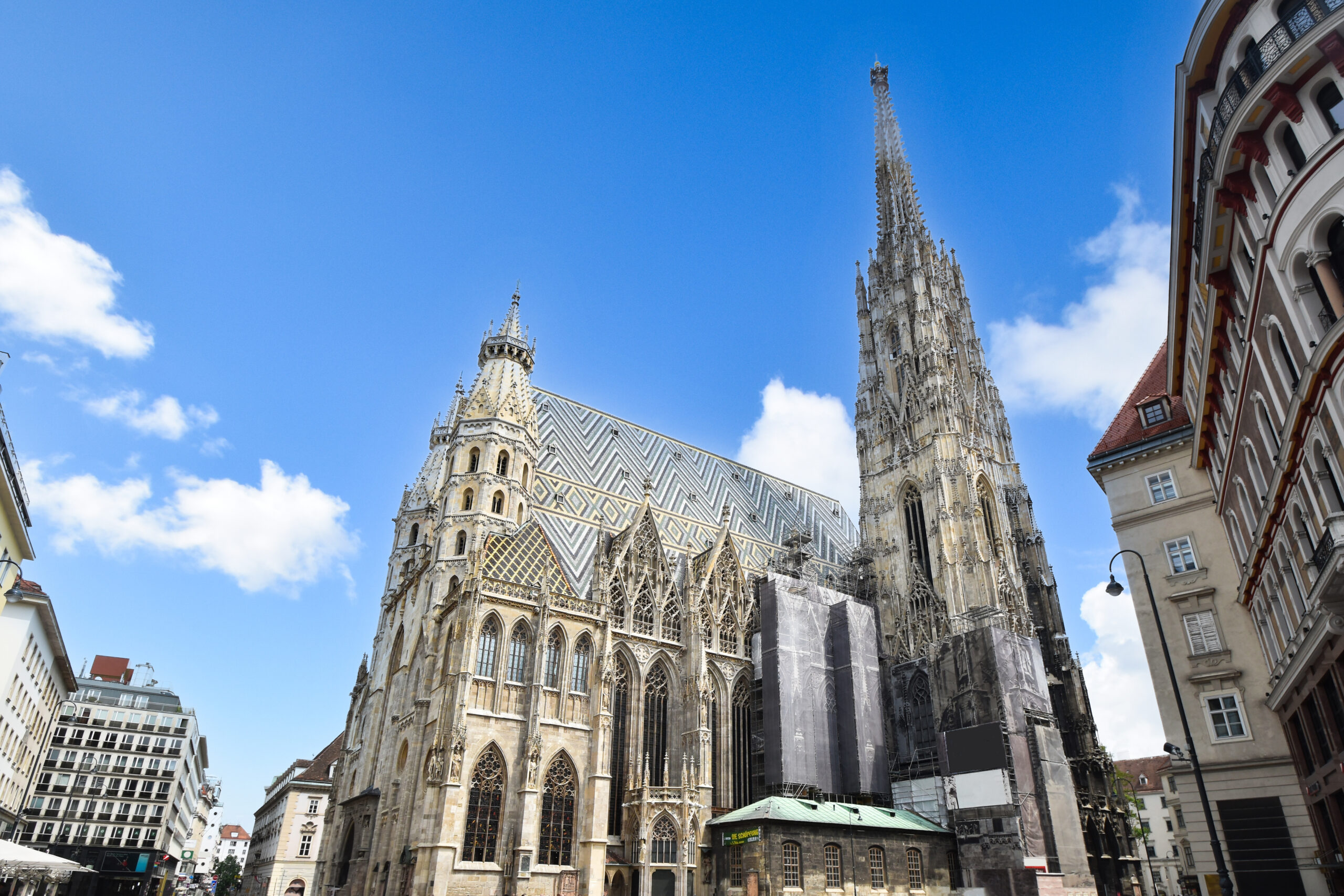 St. Stephen's Cathedral in Vienna with its ornate Gothic facade and patterned roof against a blue sky.