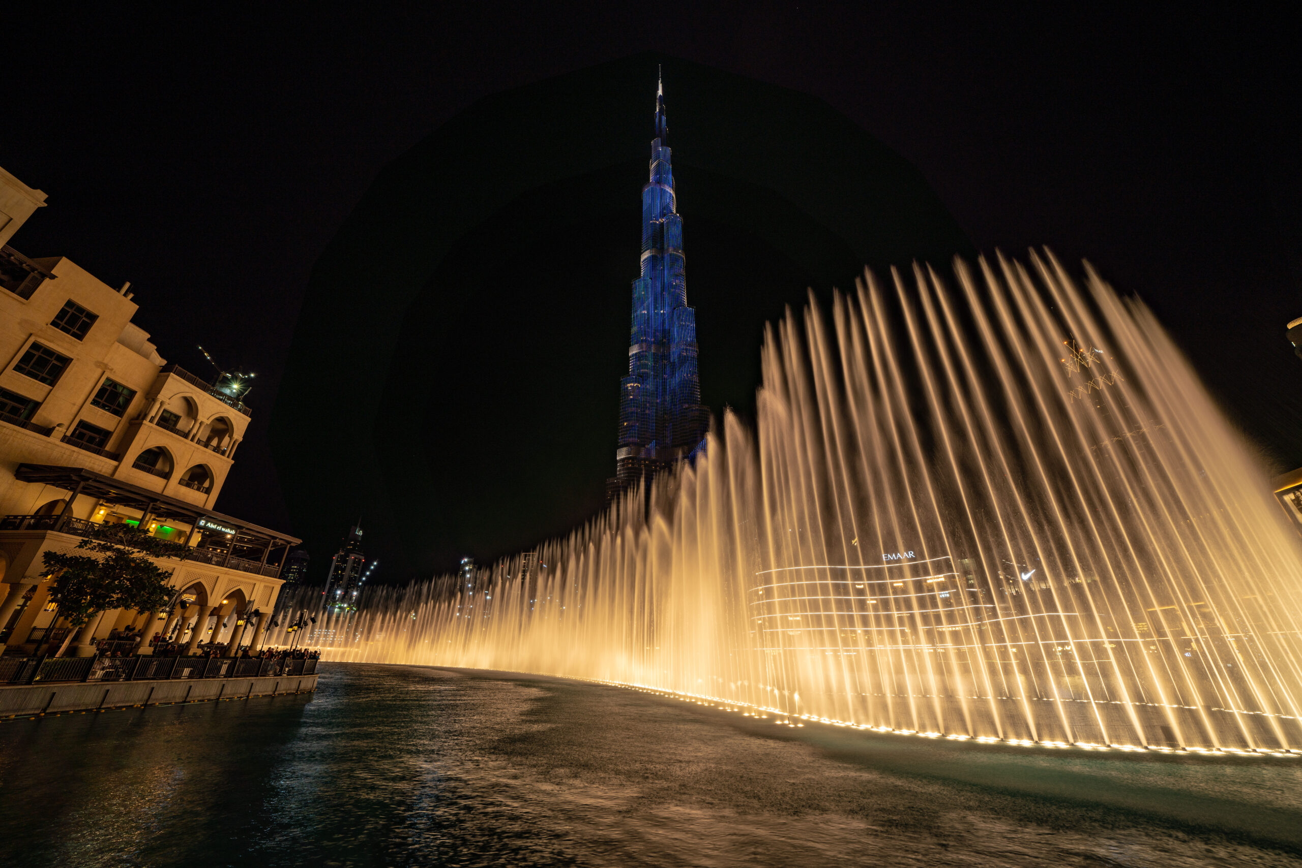 Night view of the Dubai Fountain with the Burj Khalifa lit up in the background at night