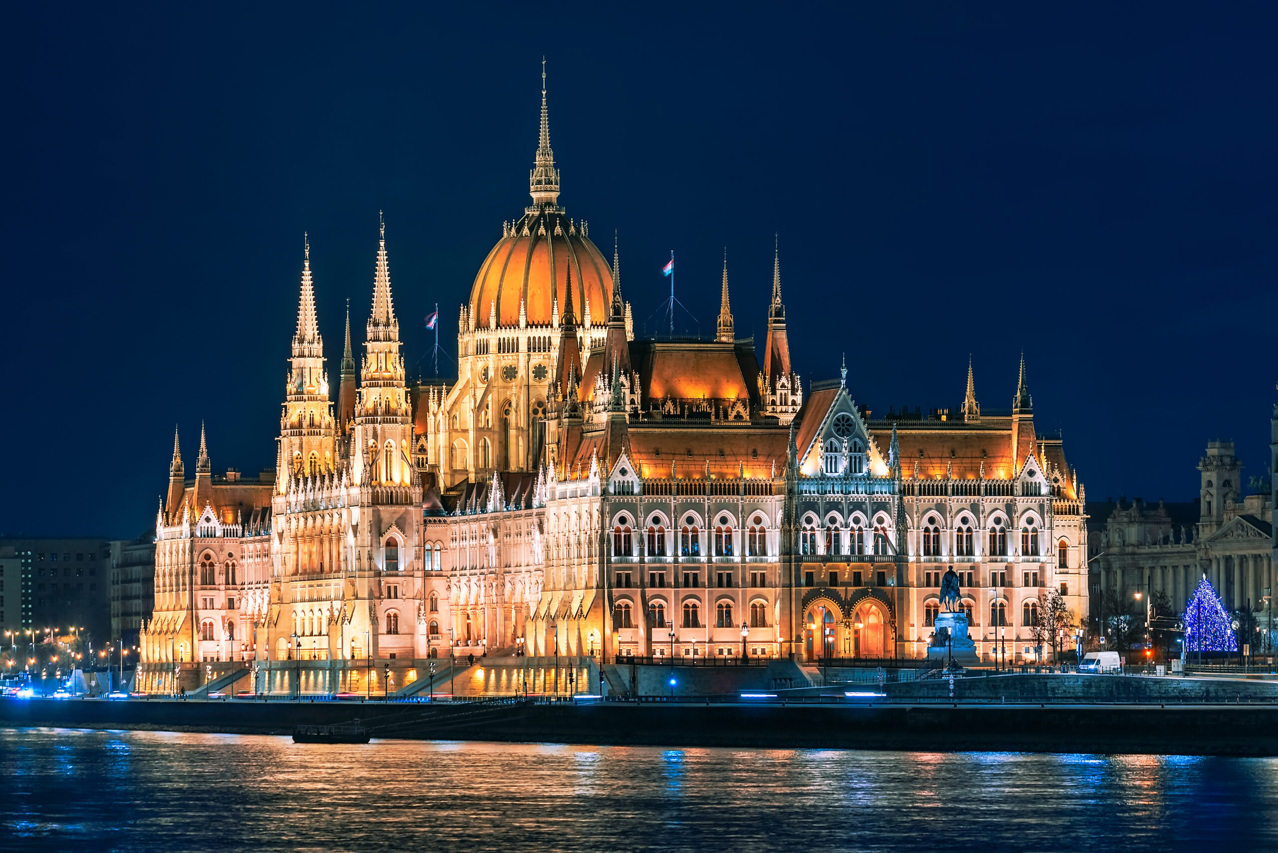 Night view of Budapest's Hungarian Parliament Building lit up along the Danube.