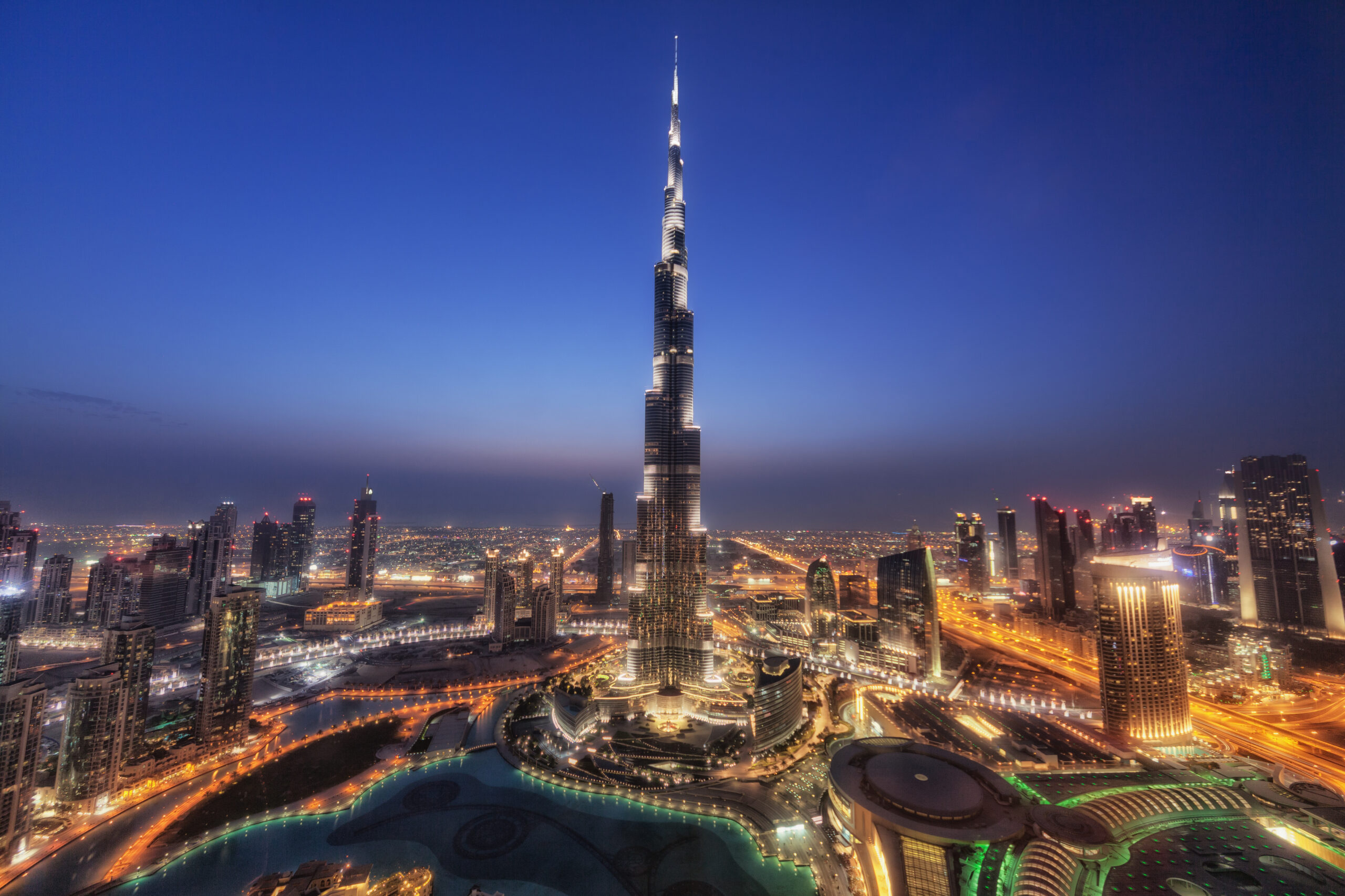 Nighttime city skyline with Burj Khalifa towering over illuminated downtown Dubai