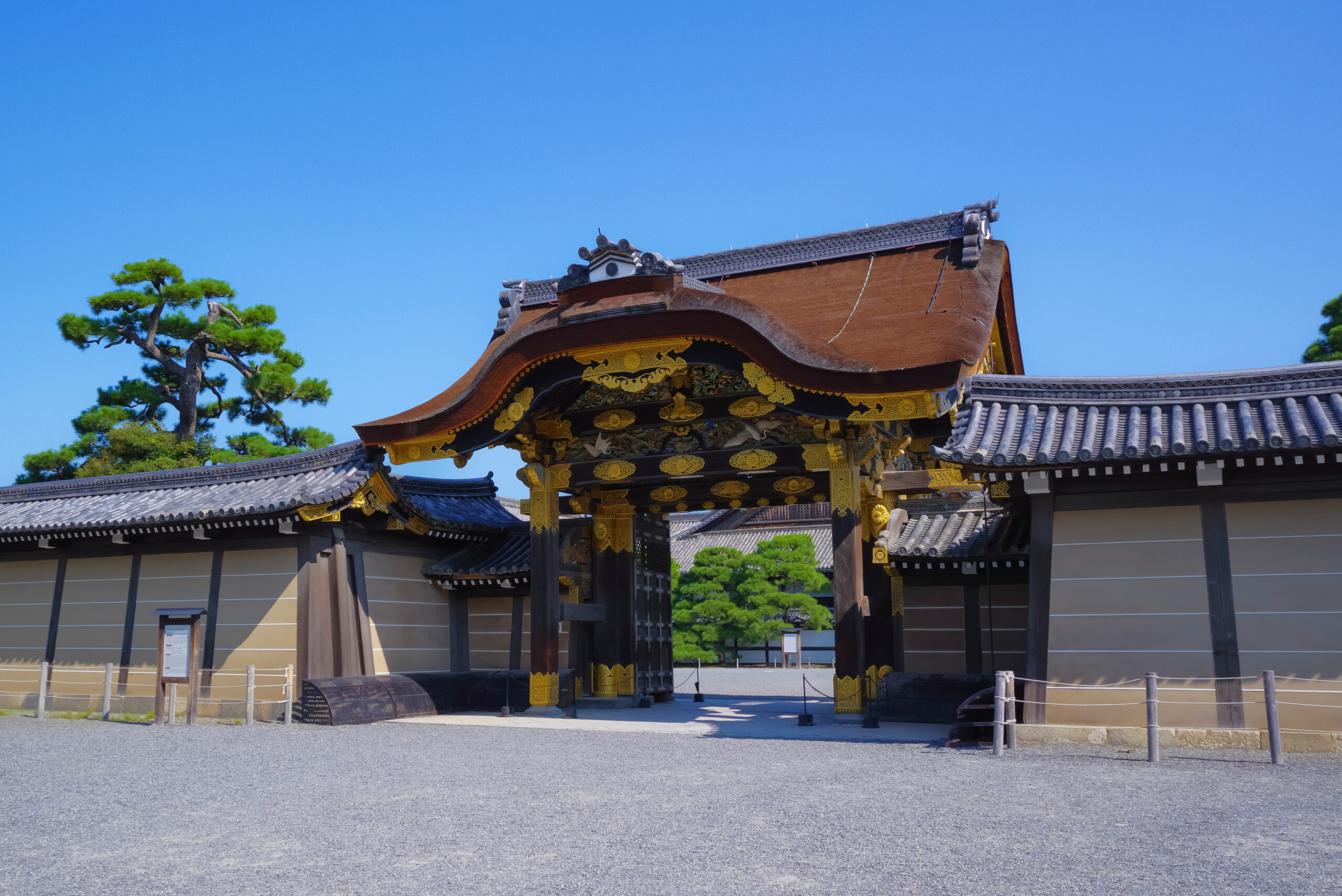 Ornate traditional temple gate with gold decorations under a clear blue sky
