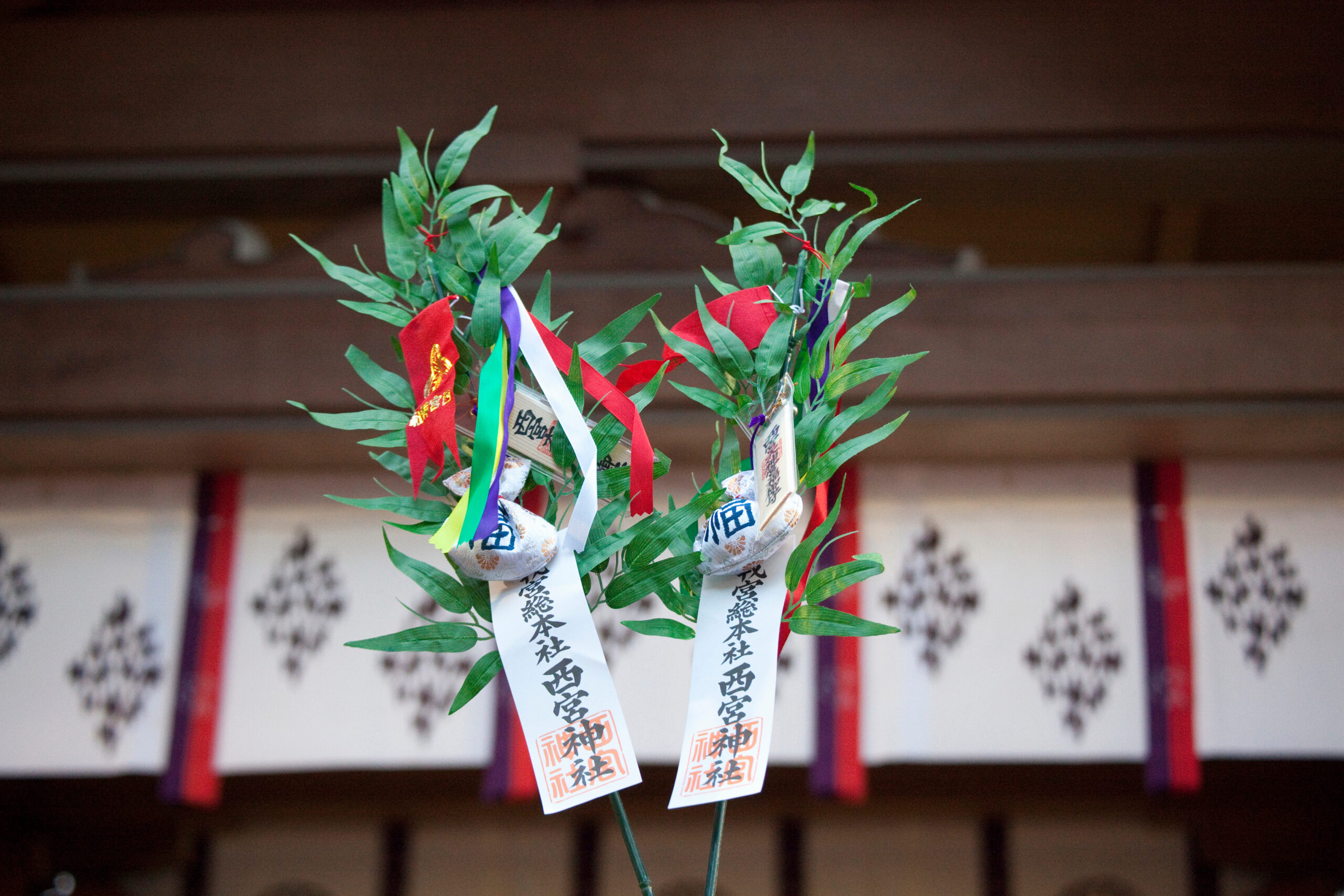 Shinto wish tree with colorful ribbons and paper talismans hanging from bamboo branches at a shrine.